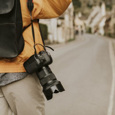 DSLR camera with strap hanging on photographer’s shoulder